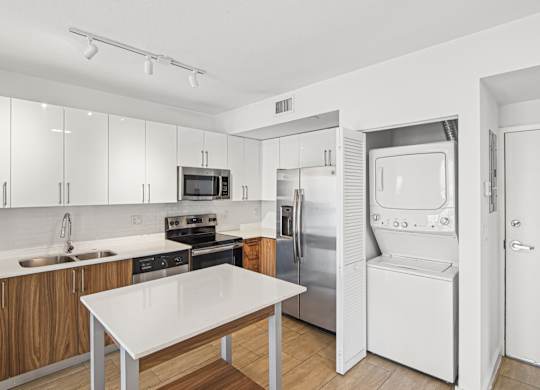 Twenty3 floor plan kitchen with table and stacked washer and dryer at Twenty2 West luxury apartments in Miami, FL