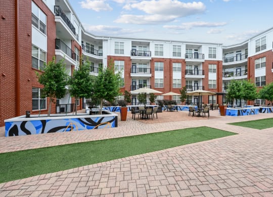 Spacious outdoor courtyard with brick pathways and greenery at The Grand at Upper Kirby apartments in Houston, TX