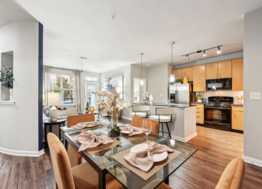 Stylish dining area and modern kitchen with pendant lighting at The Grand at Upper Kirby apartments in Houston, TX