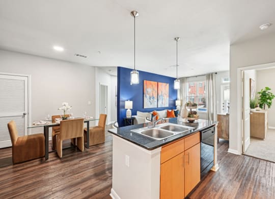 Open-concept living room and dining area with modern kitchen at The Grand at Upper Kirby apartments in Houston, TX