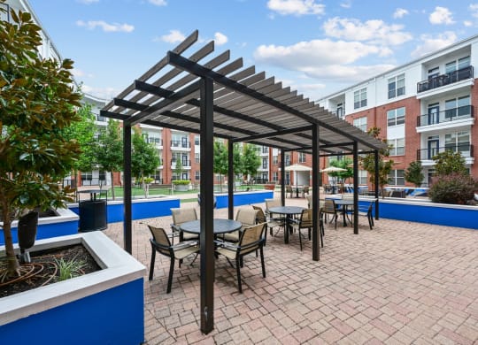 Pergola-covered outdoor dining area at The Grand at Upper Kirby apartments in Houston, TX