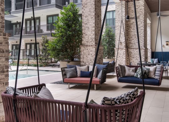 outdoor seating area next to the pool at The Alastair at Aria Village Apartment Homes in Sandy Springs, Georgia, GA
