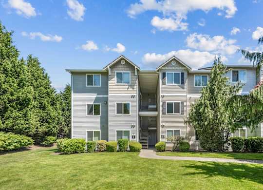 Apartment exteriors with lush greenery at The Madison apartments in Olympia, WA