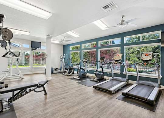 A gym with treadmills, weights, and exercise equipment at The Madison apartments in Olympia, WA