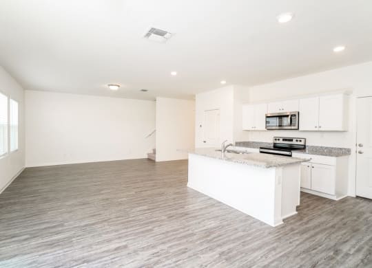 a kitchen and living room with white walls and wood flooring at Beacon at Meridian, Texas, 78245
