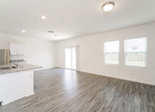 an empty living room with a kitchen in the background at Beacon at Meridian, Texas