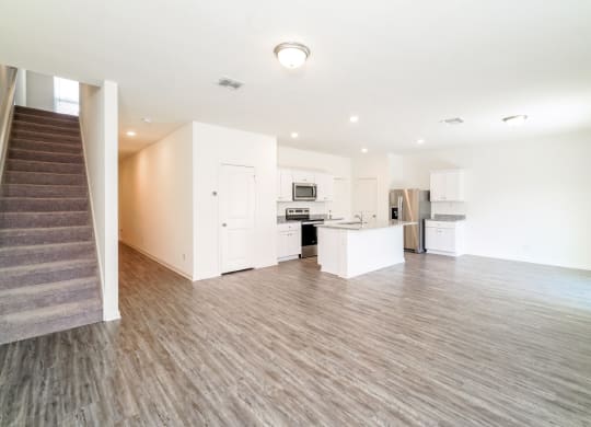 a kitchen and living room with white walls and wood flooring at Beacon at Meridian, San Antonio Texas