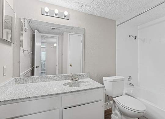 A1 bathroom with a sink, toilet, and bathtub at Vine Apartments in Arlington, TX