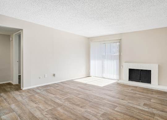 A1 living room with a fireplace and wood flooring at Vine Apartments in Arlington, TX