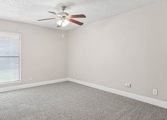 B1 bedroom with a ceiling fan and carpeted floor at Vine Apartments in Arlington, TX