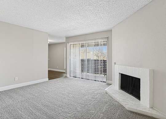 B1 Living room with a fireplace and a window with blinds at Vine Apartments in Arlington, TX