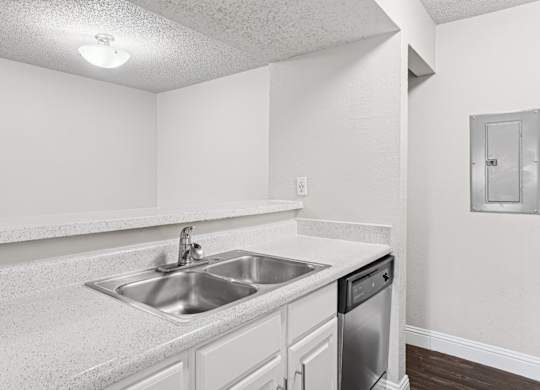 Upgraded A1 kitchen with a sink and a dishwasher at Vine Apartments in Arlington, TX
