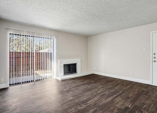 Upgraded A1 living room with a fireplace and wooden floors at Vine Apartments in Arlington, TX