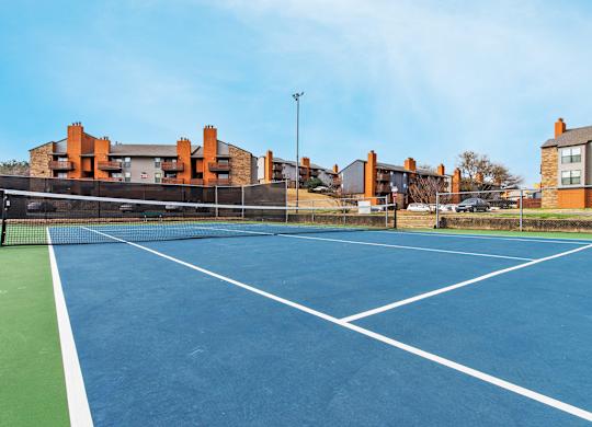 A tennis court with a green border and white lines at Vine Apartments in Arlington, TX