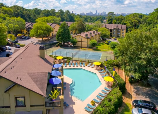 an aerial view of a resort style pool with lounge chairs and umbrellas