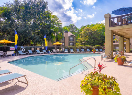 a swimming pool with lounge chairs and umbrellas at homewood suites by hilton