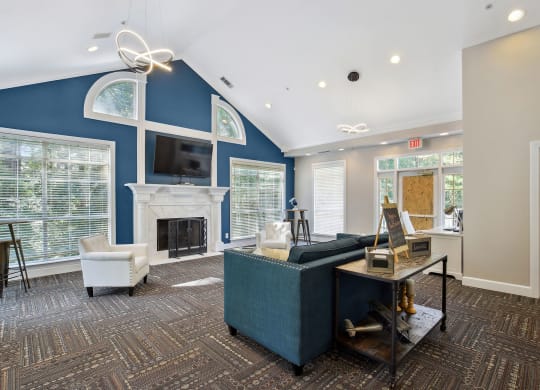 Leasing office lounge area with a blue accent wall and a fireplace at Wellington Ridge in Lawrenceville, GA