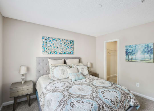 Model bedroom with a bed and two paintings on the walls at Wellington Ridge in Lawrenceville, GA
