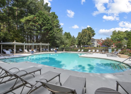 Beautiful swimming pool with poolside lounge chairs at Wellington Ridge apartments in Lawrenceville, GA