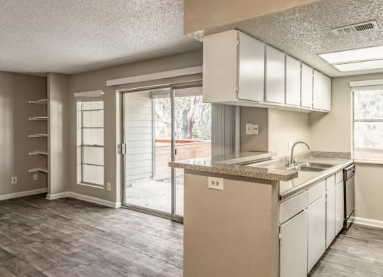 an empty kitchen with a sliding glass door to a patio