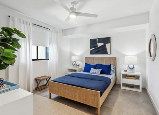Bedroom in A1 Floor Plan with blue sheets and 2 nightstands at Westgate on University in Lauderhill, FL