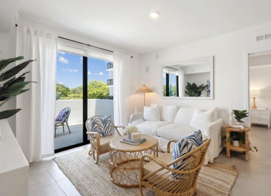Living Room in B1 Floor Plan with white couch and sliding door to balcony at Westgate on University in Lauderhill, FL
