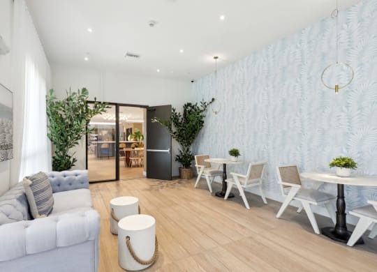 Clubhouse space with 2-person tables and a couch at Westgate on University in Lauderhill, FL