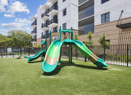 Green playground with slides at Westgate on University in Lauderhill, FL
