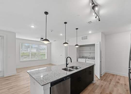B2 kitchen with a granite countertop and a sink and hanging lights at Whispering Pines at Westdale Hills in Euless, TX