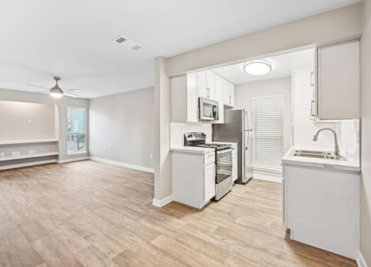 Open and airy kitchen and dining area in the D5 floor plan at Windridge On The Parkway Apartments in Dallas, TX
