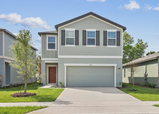 a home with a gray exterior and a brown garage door at Beacon at Woodland Village, DeLand Florida