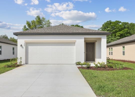 a home with a white garage door at Beacon at Woodland Village, DeLand, FL 32724