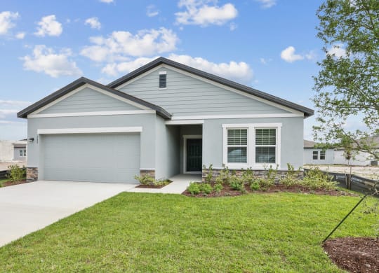 a home with a gray siding and a gray garage door at Beacon at Woodland Village, DeLand, FL 32724