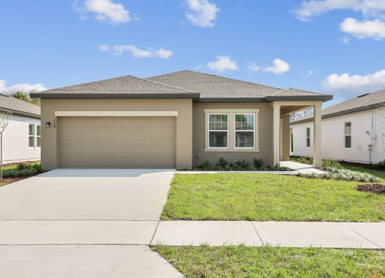 a house with a garage and a lawn at Beacon at Woodland Village, DeLand, FL