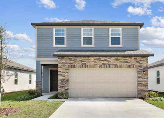 a house with a garage door in front of it at Beacon at Woodland Village, DeLand, FL