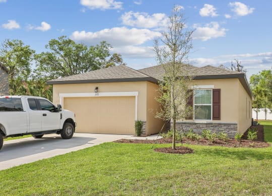 a home with a truck parked in the driveway at Beacon at Woodland Village, DeLand Florida