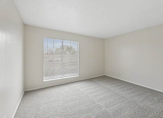 A2 Bedroom with big window and carpet flooring at Westdale Pointe in Austin, TX