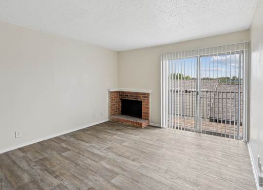 A2 living room with a fireplace and a sliding glass door at Westdale Pointe in Austin, TX