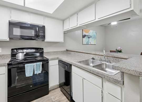 B1 kitchen with white cabinets and black appliances at Westdale Pointe in Austin, TX