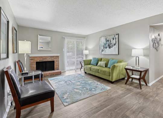 B1 living room with fireplace and green couch at Westdale Pointe in Austin, TX