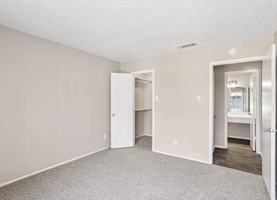 A5 bedroom looking toward the entrance and walk-in closet at Windridge on the Parkway apartments in Dallas, TX