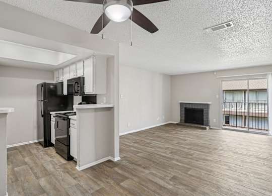 A5 kitchen and spacious living room with a fireplace and a balcony at Windridge on the Parkway apartments in Dallas, TX