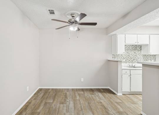 A6 dining room with a ceiling fan and vinyl wood flooring Windridge on the Parkway apartments in Dallas, TX.