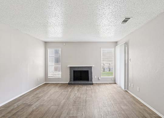 A6 living room with a fireplace and vinyl wood flooring Windridge on the Parkway apartments in Dallas, TX.