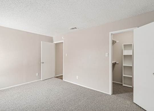 B6 bedroom with a closet, carpet, and white walls at Windridge on the Parkway in Dallas, TX