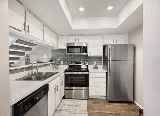 a kitchen with white cabinets and stainless steel appliances