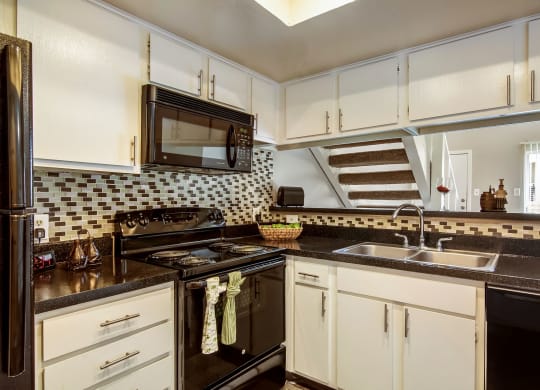 a kitchen with a sink and a stove and a microwave