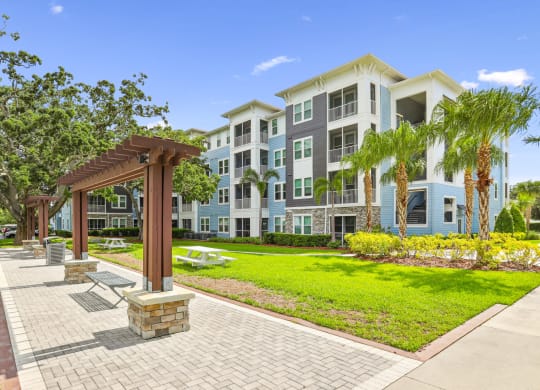 Bench seating by sidewalks and apartment buildings at Dunedin Commons apartments in Dunedin, FL