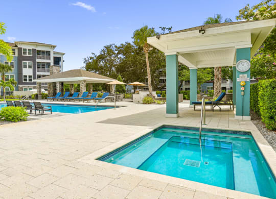 Jacuzzi with shaded seating area by the pool at Dunedin Commons apartments in Dunedin, FL
