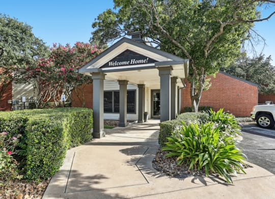 Leasing office entrance with beautiful foliage at Hunters Chase in Austin, TX